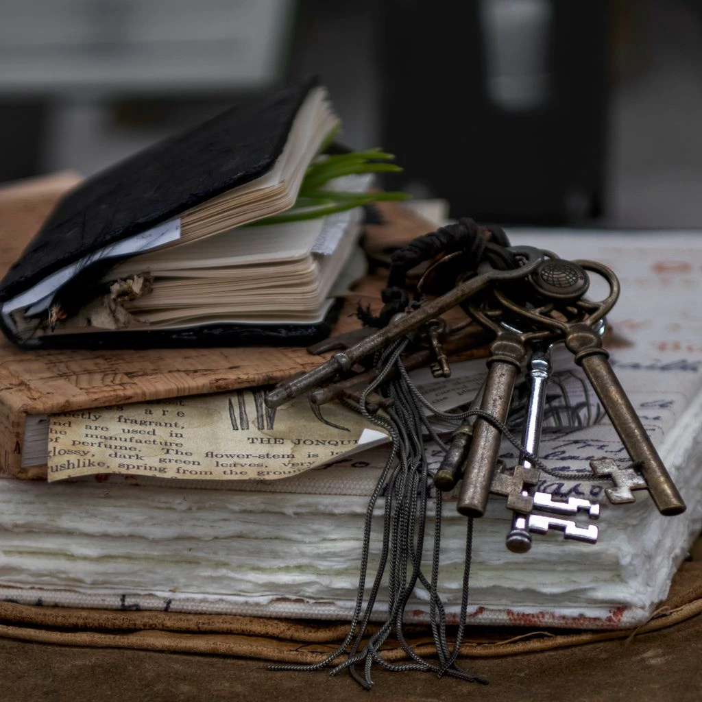 Brass room keys on ribbon beside an open guest ledger